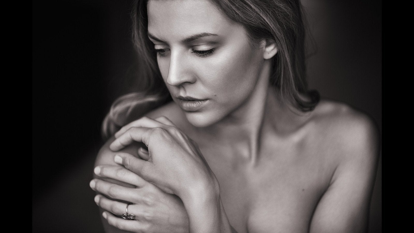 Crno-bela fotografija žene sa zatvorenim očima, koja nežno dodiruje rame – simbol unutrašnjeg mira, samopouzdanja i negovane kože uz svakodnevnu rutinu sa Premier Collagen-om.